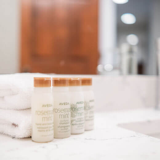 Close-up of hotel toiletries and clean white towels.