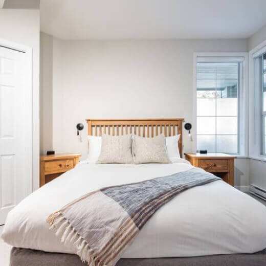 Comfortable guest bedroom with a queen bed and wooden headboard.